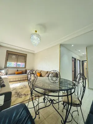a living room with a table and a couch at Al Waha Prestige Apartment in Marrakech