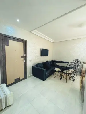 a living room with a black couch and a table at Al Waha Prestige Apartment in Marrakech