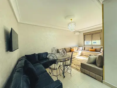a living room with a couch and a table at Al Waha Prestige Apartment in Marrakech