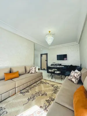 a living room with a couch and a table at Al Waha Prestige Apartment in Marrakech