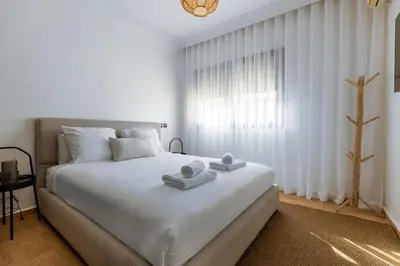a white bedroom with a large bed with towels on it at One bedroom studio in Guéliz, pool & gym in Marrakech