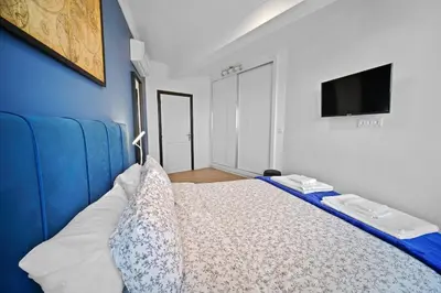 a bedroom with a blue couch and a tv at Centre Town Cozy Apartment with Panoramic View in Marrakech