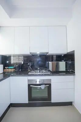 a kitchen with white cabinets and a stove top oven at Modern apartments, cozy residence, swimming pools in Marrakech