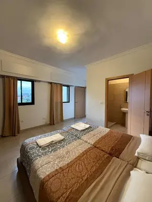 a bedroom with a large bed with two towels on it at Cozy Flat , Resort-Style Pool ,10 min to Center in Marrakech