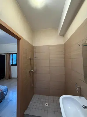 a bathroom with a shower and a tub and a sink at Cozy Flat , Resort-Style Pool ,10 min to Center in Marrakech