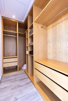 a walk in closet with wooden shelves and cabinets at Momiji Golf Villa - Private Heated Pool in Marrakech