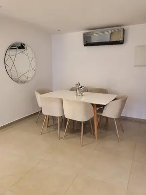a dining room with a white table and chairs at Luxury Apartment Les Cerisiers Marrakech in Marrakech
