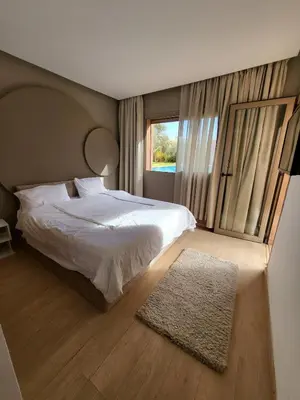 a bedroom with a bed and a large window at Luxury Apartment Les Cerisiers Marrakech in Marrakech