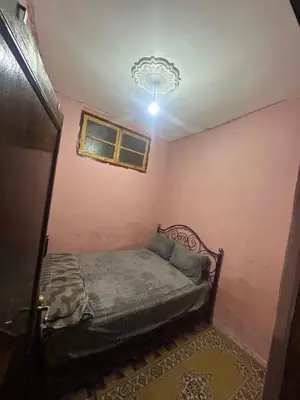 a small bedroom with a bed and a chandelier at Maison confortable pour familles in Zaouia El Hedil Mamra