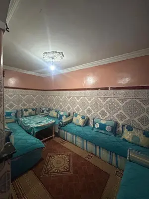 a living room with blue couches in a room at Maison confortable pour familles in Zaouia El Hedil Mamra