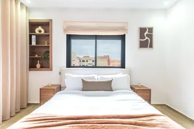 a bedroom with a large white bed and a window at Menara Suite Harmonie , Terrasse et Piscine in Marrakech