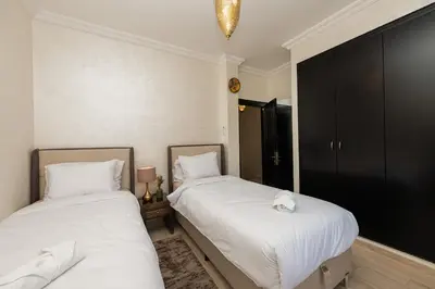 two beds in a bedroom with white sheets at Villa Sara - 3 Rooms with private pool in Marrakech