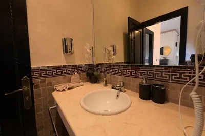 a bathroom with a sink and a large mirror at Villa Sara - 3 Rooms with private pool in Marrakech