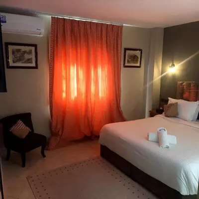 a bedroom with a bed and a window with an orange curtain at Lyron Hostel & Privates rooms Gueliz in Marrakech