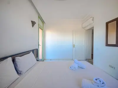 a white room with a bed with towels on it at Séjour Élégant et raffiné à Hivernage 2 ch & parking privé in Marrakech