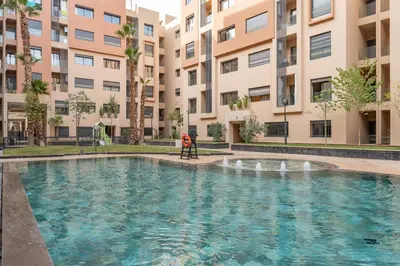 a swimming pool in front of a building at Le Lotus - Piscine intérieur et extérieur - Wifi - Fitness in Marrakech