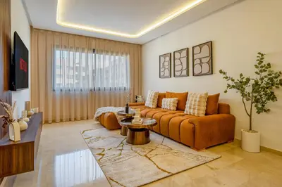 a living room with a couch and a table at Le Lotus - Piscine intérieur et extérieur - Wifi - Fitness in Marrakech