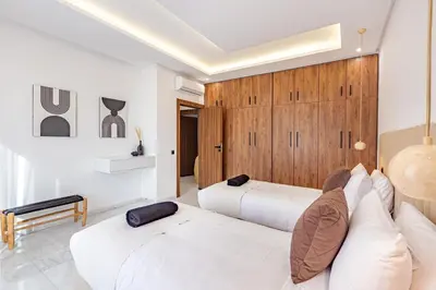 two beds in a room with wooden cabinets at Private Luxury Penthouse Marrakech with Jacuzzi & Pool in Marrakech