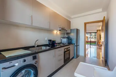 a kitchen with a sink and a washing machine at Noria Golf Marrakech pool view 2 bedrooms garden in Marrakech