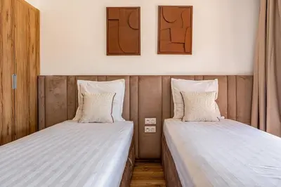 two beds sitting next to each other in a room at Noria Golf Marrakech pool view 2 bedrooms garden in Marrakech