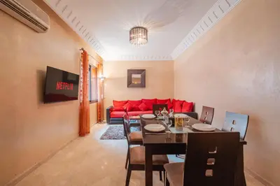 a living room with a red couch and a table at Almaya Stay City Center in Marrakech