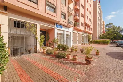 a building on a street with potted plants on the sidewalk at Almaya Stay City Center in Marrakech