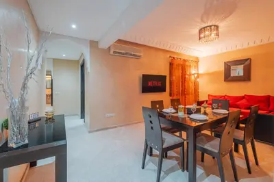 a dining room with a table and a red couch at Almaya Stay City Center in Marrakech