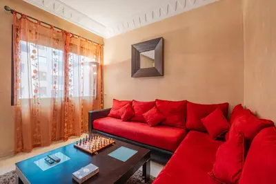 a living room with a red couch and a table at Almaya Stay City Center in Marrakech
