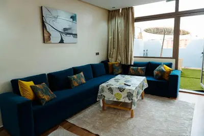 a blue couch in a living room with a table at Appartement moderne in Marrakech