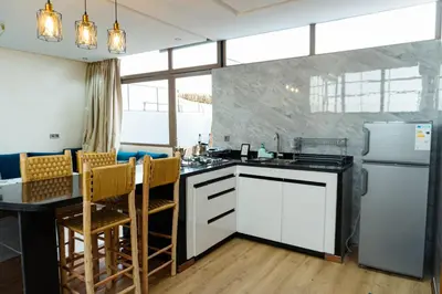 a kitchen with white appliances and a table with chairs at Appartement moderne in Marrakech
