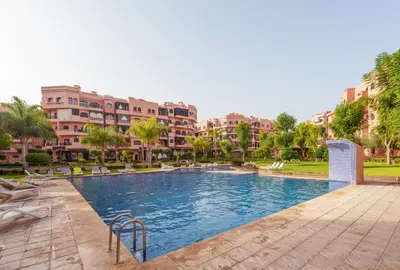 a swimming pool in a resort with buildings in the background at New 2BR Apartment in Marrakech with Pools, Gym, Security & Terrace in Marrakech