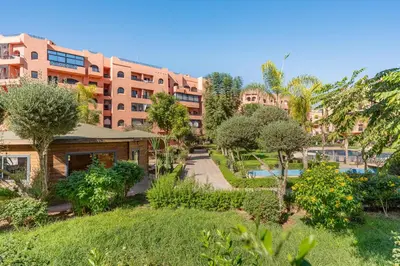 an apartment complex with a garden in front of a building at New 2BR Apartment in Marrakech with Pools, Gym, Security & Terrace in Marrakech