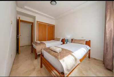a bedroom with two beds and a table in it at Luxury apartment in Hivernage in Marrakech