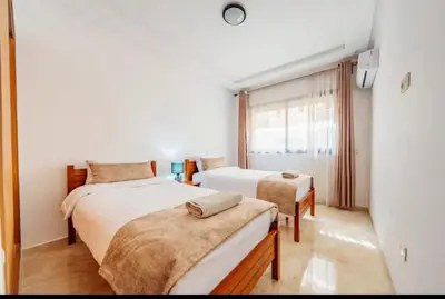 a bedroom with two beds and a window at Luxury apartment in Hivernage in Marrakech
