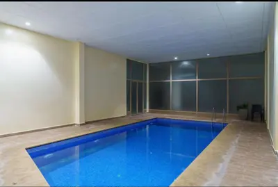 a large swimming pool in a building with a blue floor at Luxury apartment in Hivernage in Marrakech