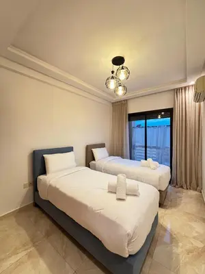 a bedroom with two beds and a chandelier at Cozy opera - Hivernage - Gare in Marrakech