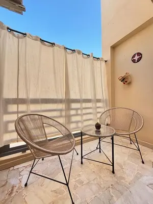 two chairs and a table in front of a window at Cozy opera - Hivernage - Gare in Marrakech