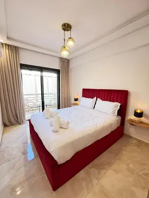 a bedroom with a large bed with a red headboard at Cozy opera - Hivernage - Gare in Marrakech