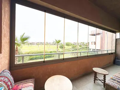 a room with a large window with a view of a field at Prestigia Golf View - Piscine & terrasse in Marrakech
