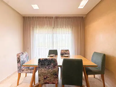 a dining room with a table and chairs at Prestigia Golf View - Piscine & terrasse in Marrakech