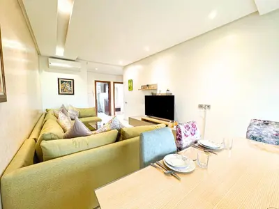 a living room with a couch and a table at Prestigia Golf View - Piscine & terrasse in Marrakech