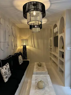 a living room with a black couch and a chandelier at Private Riad in Marrakech Medina in Marrakech