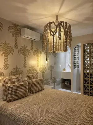 a bedroom with a large bed and a chandelier at Private Riad in Marrakech Medina in Marrakech