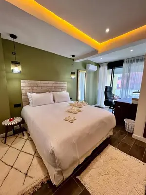 a large white bed in a room with a piano at Appartement Luxe 2 Chambres Guéliz Centre Calme & Prestations Haut de Gamme in Marrakech