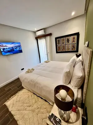 a bedroom with a large bed and a table with a lamp at Appartement Luxe 2 Chambres Guéliz Centre Calme & Prestations Haut de Gamme in Marrakech