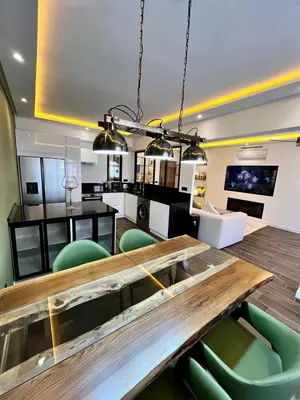 a dining room with a wooden table and green chairs at Appartement Luxe 2 Chambres Guéliz Centre Calme & Prestations Haut de Gamme in Marrakech