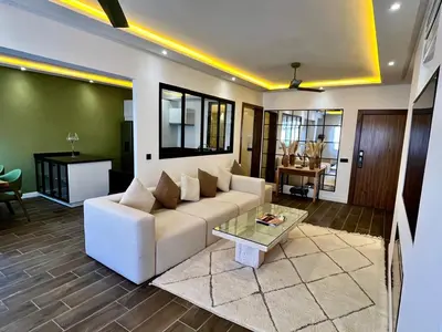 a living room with a white couch and a table at Appartement Luxe 2 Chambres Guéliz Centre Calme & Prestations Haut de Gamme in Marrakech