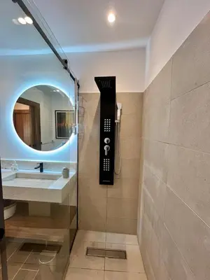 a bathroom with a shower and a sink and a mirror at Appartement Luxe 2 Chambres Guéliz Centre Calme & Prestations Haut de Gamme in Marrakech