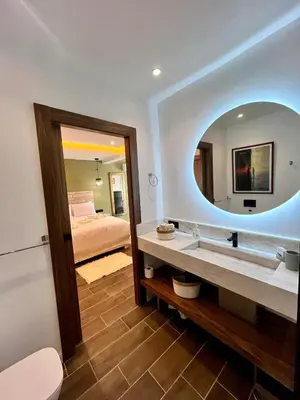 a bathroom with a sink and a mirror and a bed at Appartement Luxe 2 Chambres Guéliz Centre Calme & Prestations Haut de Gamme in Marrakech