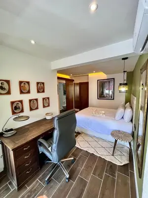 a bedroom with a bed and a desk and a chair at Appartement Luxe 2 Chambres Guéliz Centre Calme & Prestations Haut de Gamme in Marrakech